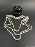 Photo showing the full six foot pearl strand next to a 3 inch green apple for size reference.