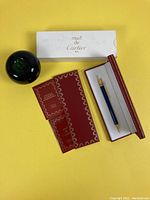 Overview of pen, presentation box, sleeve, certificate booklets and green apple size reference