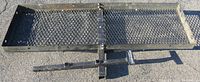 Top view of black metal rectangular cargo carrier rack made from expanded metal mesh with solid edges and attachment for hitch receiver.