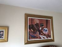 Framed large artwork showing African queen and male figure with ornamental gold-tone frame