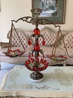 Full view of art glass scale showing ornate metal stand with hanging red teardrop crystals, marble base, and two colorful marbled glass weighing pans.