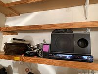 Sony AV receiver STR-KS2300 and single Sony SS-SRP23S speaker with assorted cables on a wooden shelf
