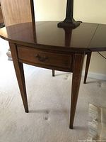 Front left side view showing drawer and tapered leg with inlaid decoration on wood end table