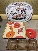 Four serving trays arranged on floor showing the full set and details of color and shape.