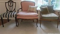 Photo showing three different vintage chairs: striped fabric chair, peach velvet chair, and caned armchair with embroidery.
