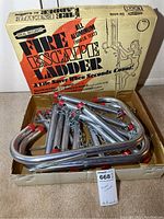 Fire escape ladder aluminum segments and chains in an open box with original packaging showing branding and weight capacity.