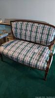 Front view of the loveseat showing plaid pattern upholstery and wooden frame.