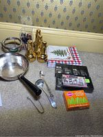 Overview of brass/gold-tone salt and pepper shakers, metal bowl, sterling ladle and tongs, napkins, placecard holders, and toothpicks.