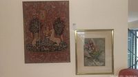Photo of two framed prints hanging on a white wall; left piece features mythological creatures, right piece is a botanical floral print