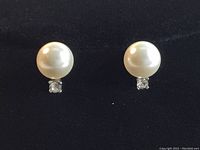 Front view showing the white Swarovski crystal pearl and small clear crystal detail on the earrings.