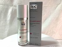 Front view of the RoC Clarifiant Concentrated Clarifying Serum 40ml bottle and its box on a white fabric surface, showing label and packaging.