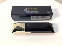 Photo of the black faceted Clé de Peau Beauté Sylomine lipstick holder with box, showing front side and packaging details.