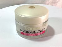 Clear glass jar with white lid and product labeling showing brand and product name.