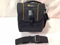 Front view of closed Lowepro Adventura SH 140 II camera bag with shoulder strap laid in front