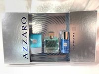 Front view of luxury gift box with silver packaging showing the perfume bottle, after shave balm, and deodorant stick inside.