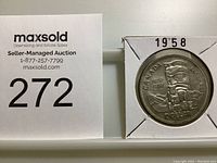 Front side of the 1958 Canadian silver dollar coin showing the totem pole design, the year 1858-1958, and 'CANADA DOLLAR' inscription.