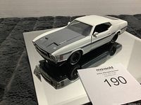 White and gray collectible muscle car model on reflective surface showing overall exterior condition and styling