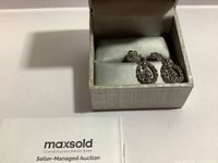 Pair of silver filigree drop earrings marked 925, displayed in a grey jewelry box on white surface with visible MaxSold Seller Managed Auction card