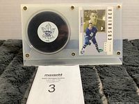 Showing the hockey puck and Tim Horton hockey card inside the acrylic case with screw fixtures