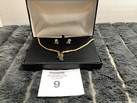 Full view of Vendome necklace and earrings in black and white box on gray surface with auction tag