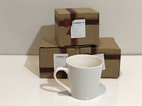 Coffee cups displayed in front of their respective packaging boxes with bow print.