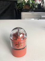 Closed view of the compact 4-in-1 medicine pillbox showing its transparent cutting section and terracotta colored body.