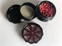 Photo showing the four disassembled parts of the spice grinder: lid with sharp teeth, middle section with teeth, fine mesh filter, and bottom compartment.