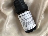 Front label of Amber Arctic Organic Plant Essential Oil bottle detailing product name and benefits.