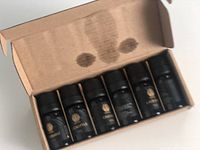 Top-down view of unopened box with six essential oil bottles visible inside their slots.