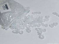 Close-up of plastic hooks inside original packaging, showing translucent 'S' shaped hooks.