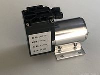 Side view of mini vacuum pump showing product label with model and specifications.