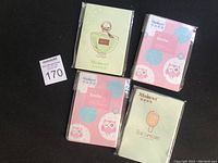 Four boxes of face oil paper sheets, each with different colorful designs, individually wrapped in clear plastic.