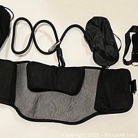 Neck traction hammock laid out showing soft cushioned gray and black fabric, hanging rope with metal hook