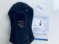 Black fabric posture corrector with 'SEMIEN' logo patch, new in package with accompanying information sheet.