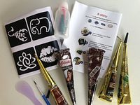 Overview of tattoo kit with henna cones, instruction sheet, stencil sheet, small bottle and applicators