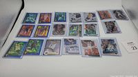 Group shot of 19 basketball cards with silver and blue prizm foil finishes, placed on a white surface.