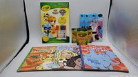 Lot showing the Crayola Paw Patrol activity pad with markers, Crayola crayons box, rainbow scratch booklet, and two other coloring books.
