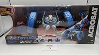 Front view of boxed New Bright RC Stunt Acrobat vehicle showing branding and features such as 360° spinning and light-up.