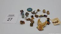 Overview photo of 17 vintage pins laid out on white surface showing variety of designs including flags, character, eagle, and airplane pins.