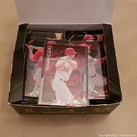 Box opened showing multiple 2013 Panini Pinnacle baseball cards, the top card featuring Bryce Harper in a batting pose with white uniform.