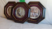 Framed set of three octagonal panels with round collector plates by Trisha Romance. Plates depict women and children in indoor domestic scenes with a vintage style.
