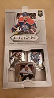 Box of Panini Prizm NHL hockey trading cards open showing cards inside, front with player image and logo