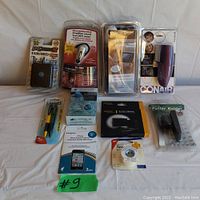 Full lot of 10 new sealed accessories items arranged on white cloth background.