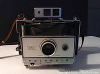 Front view of the Polaroid Automatic 350 Land Camera showing lens, shutter button, and branding.