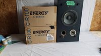 Two Energy C-Series C-R100 speakers in original boxes and vintage worn Sansui SP-X3000 speaker standing vertically showing woofer and tweeter with front port hole
