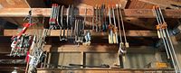 Wide view of multiple clamps hanging from ceiling joists
