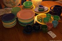 Overall assortment of stacked Fiesta plates, bowls and cups on tabletop