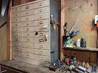 Front view of metal toolbox on workbench with surrounding tools