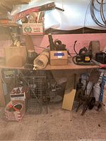 Wide view of the Powr-Kraft radial shop machine under a workbench surrounded by cords and miscellaneous items