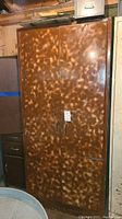 Full view of large metal storage cabinet with mottled finish and double doors